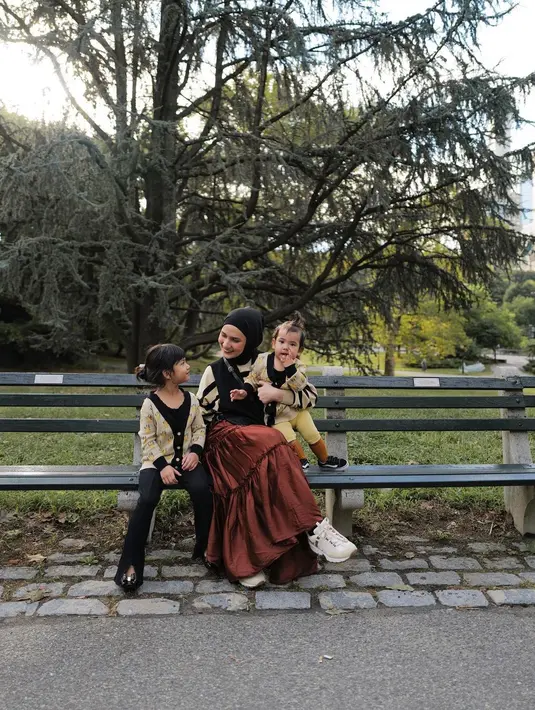 Dwi Handayani kembali berpose dengan kedua buah hatinya dengan outfit bernuansa musim gugur. Ketiga mengenakan atasan senada bernuansa hitam-kuning keemasan bermotif abstrak. Dwi Handayani memadukannya dengan ruffles skirt berwarna cokelat gelap, sedangkan kedua buah hatinya tampak mengenakan celana panjang hitam dan legging kuning. Foto: Instagram.