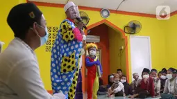 Yahya Edward menggunakan kostum badut berceramah di depan anak-anak di Pinang, Kota Tangerang, Banten, Kamis (29/4/2021). Mengajar ngaji menggunakan kostum badut tersebut untuk memotivasi anak-anak agar tetap semangat belajar sekaligus untuk menghibur anak didiknya. (Liputan6.com/Angga Yuniar)