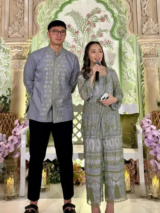 Nikita Willy mengenakan baju lebaran one set warna dasar abu-abu dengan payetan warna hijau. Senada dengan baju koko suaminya. [@yorafebrina]