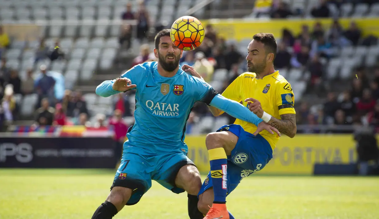 Pemain Barcelona, Arda Turan (kanan) berebut bola dengan pemaing Las Palmas, Momo pada lanjutan La Liga Spanyol pekan ke-25 di Stadion Gran Canaria, Las Palmas de Gran Canaria, Sabtu (20/2/2016) malam WIB. (AFP / Jaime Reina)