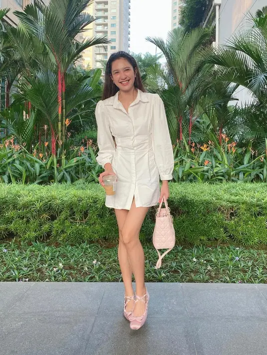 Atau penampilan simpel Mikha Tambayong di foto ini. Ia mengenakan shirt-dress lengan panjang berwarna putih dan ballet shoes merah muda yang manis. [Foto: Instagram/miktambayong]
