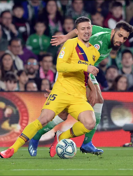 Bek Barcelona, Clement Lenglet (kiri) berebut bola dengan pemain depan Real Betis, Borja Iglesias pada lanjutan Liga Spanyol pekan ke-23 di Benito Villamarin, Minggu (9/2/2020). Diwarnai dua kartu merah, Barcelona mememangkan duel menegangkan lawan Real Betis 3-2. (CRISTINA QUICLER/AFP)