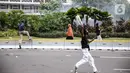 Seorang perempuan berlari di tengah massa pendemo yang terlibat bentrok dengan polisi di kawasan Patung Kuda, Jakarta, Selasa (13/10/2020). Perempuan yang terjebak itu diselamatkan pendemo saat unjuk rasa menolak Omnibus Law Undang-Undang Cipta Kerja tersebut ricuh. (Liputan6.com/Faizal Fanani)