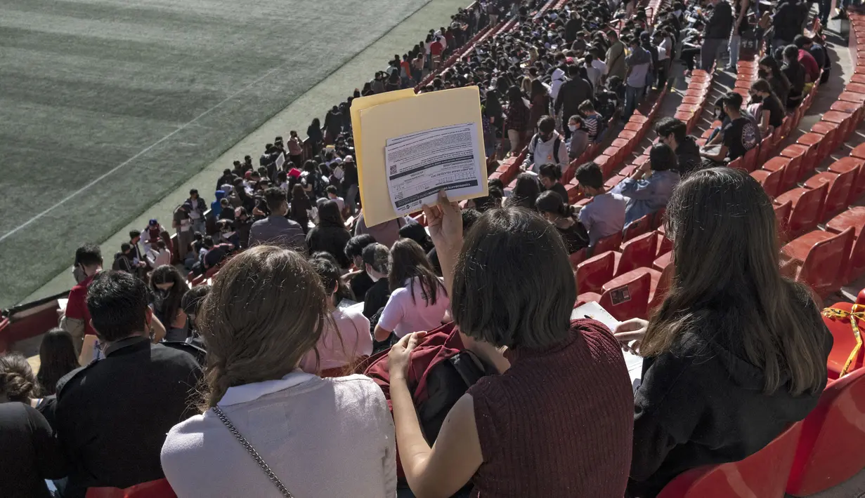 Anak-anak mengisi formulir saat menunggu usai divaksin COVID-19 dalam program vaksinasi untuk anak-anak berusia 15 hingga 17 tahun di Stadion Caliente, Tijuana, Baja California, Meksiko, 24 November 2021. Meksiko bersiap menghadapi gelombang keempat infeksi COVID-19. (Guillermo Arias/AFP)
