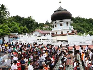 Sejumlah warga melaksanakan Salat Jumat di halaman Masjid Jami Quba, Pidie Jaya, Aceh, Jumat (9/12). Gempa berkekuatan 6,5 SR telah merobohkan ratusan bangunan termasuk Masjid Jami Quba. (Liputan6.com/Angga Yuniar)