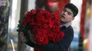Seorang anak laki-laki membawa mawar pada Hari Valentine di Kabul, Afghanistan, Minggu (14/2/2021). Hari Valentine menjadi budaya baru dalam masyarakat Afghanistan yang konservatif. (AP Photo/Rahmat Gul)