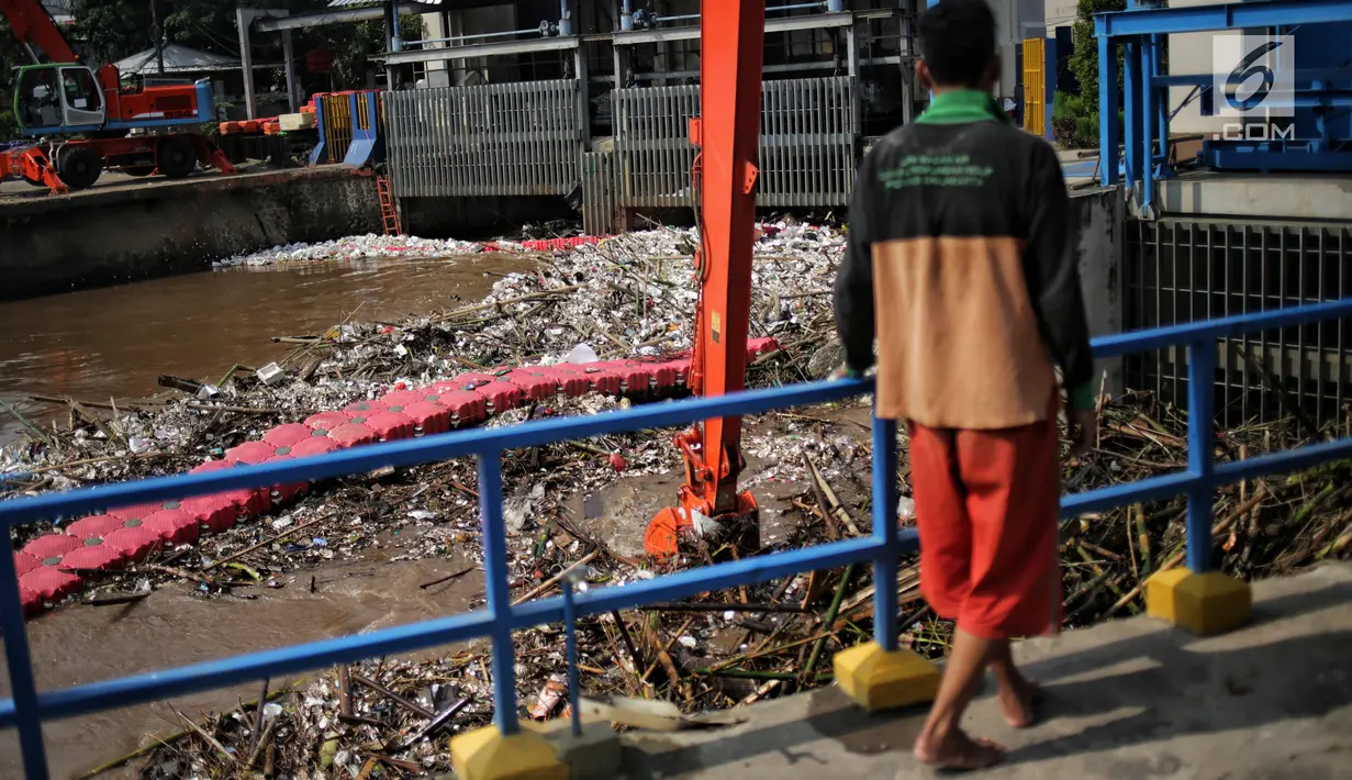 Petugas kebersihan mengeruk sampah menggunakan alat berat di Pintu Air Manggarai, Jakarta, Selasa (26/2). Meningkatnya debit air Sungai Ciliwung menyebabkan terjadi penumpukan sampah di Pintu Air Manggarai. (Liputan6.com/Faizal Fanani)