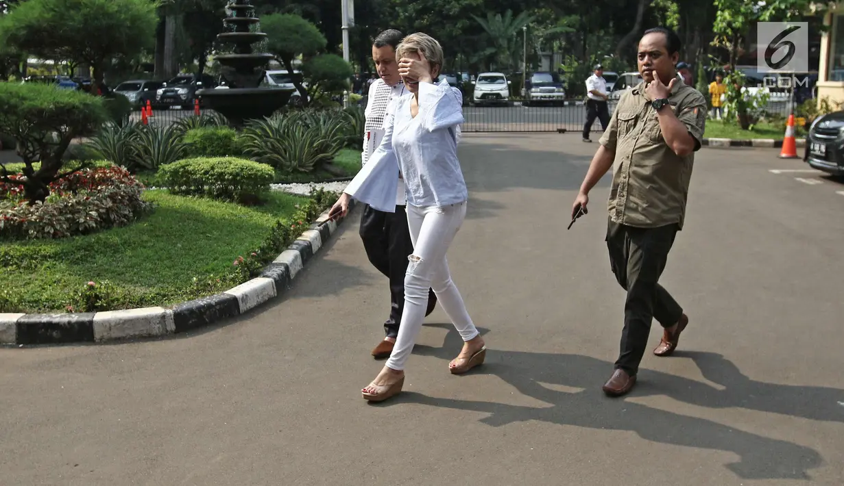 Nikita Mirzani menutupi wajahnya saat tiba di Ditreskrimsus Polda Metro Jaya, Jakarta, Jumat (20/10). Nikita jalani pemeriksaan sebagai saksi korban terkait kasus cuitan di twiter soal panglima TNI dan kasus Sam Aliano. (Liputan6.com/Herman Zakharia)
