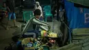 Sementara, beberapa rumah warga dan warung memakai lampu emergency maupun genset. Tampak dalam foto, seorang pria memasak untuk para pengungsi di tempat penampungan daruratnya setelah kehilangan rumahnya akibat banjir bandang di Aceh Tamiang, pada Selasa 16 Desember 2025. (Yasuyoshi Chiba/AFP)