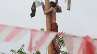 Peserta berhasill menggapai puncak pohon pinang yang dipenuhi hadiah saat lomba panjat pinang di Perumahan Griya Pamulang 2, Tangsel, Jumat (17/8). Lomba yang diselengarakan Bina Remaja ini dalam rangka memeriahkan HUT Ke-73 RI. (Merdeka.com/Dwi narwoko)