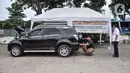 Petugas melakukan uji emisi mobil milik warga di IRTI Monas, Jakarta, Rabu (15/2/2023). Pemerintah Provinsi DKI Jakarta melalui Dinas Lingkungan Hidup dan Dinas Perhubungan mulai menerapkan tarif disinsentif (tarif parkir tertinggi) di 11 lahan parkir bagi mobil yang tidak lolos uji emisi. (merdeka.com/Iqbal S. Nugroho)