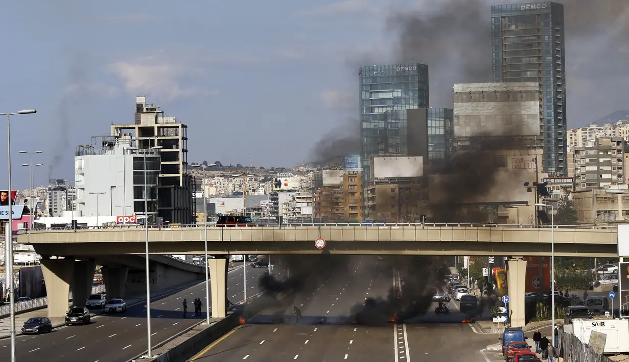 Demonstran antipemerintah membakar ban untuk memblokir jalan saat protes menentang elite penguasa di Kota Jal el-Dib, Lebanon, Selasa (14/1/2020). Demonstran menganggap elite penguasa gagal mengatasi ekonomi yang menurun tajam. (AP Photo/Bilal Hussein)