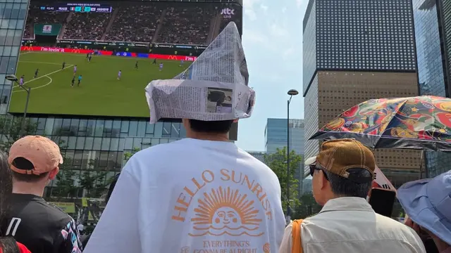 Suasana nobar Korea Selatan vs Meksiko di Gwanghwamun Plaza. Cuaca terik di tengah musim panas membuat suporter kreatif mencari cara melindungi diri. (Ratnaning Asih/ Liputan6.com)