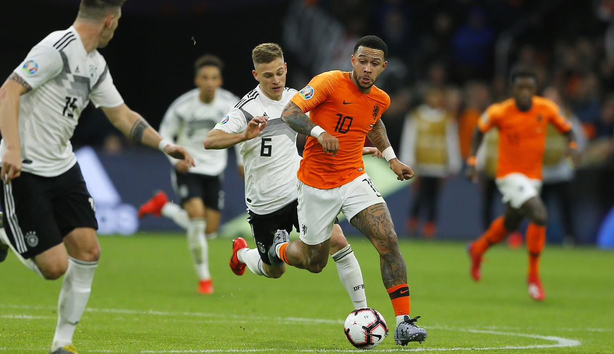 Penyerang Belanda, Memphis Depay, berusaha melewati bek Jerman, Joshua Kimmich, pada laga kualifikasi Piala Eropa di Stadion Johan Cruyff, Minggu (24/3). Belanda takluk 2-3 dari Jerman. (AP/Peter Dejong)