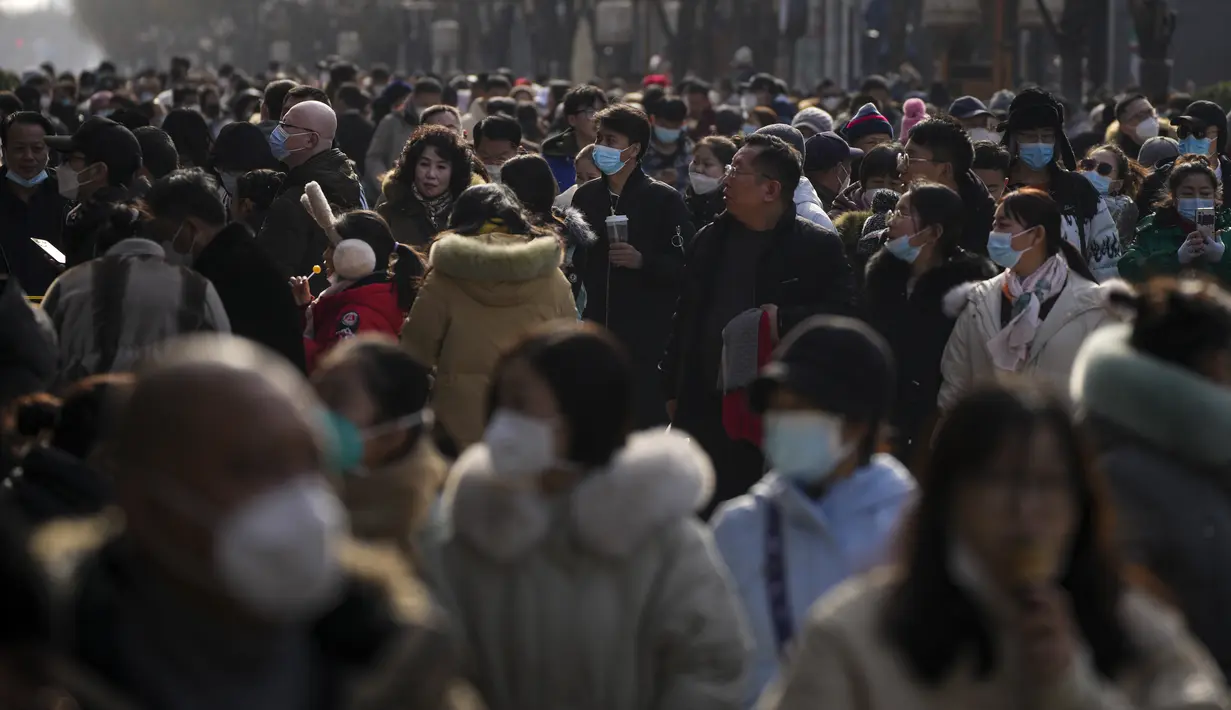 Pengunjung mengunjungi jalan perbelanjaan pejalan kaki di Qianmen pada hari pertama liburan Tahun Baru Imlek di Beijing, Minggu (22/1/2023). Orang-orang di seluruh China merayakan Tahun Baru Imlek pada hari Minggu dengan pertemuan keluarga besar dan kerumunan orang mengunjungi kuil-kuil setelah pemerintah mencabut kebijakan "nol-COVID" yang ketat, menandai perayaan meriah terbesar sejak pandemi dimulai tiga tahun lalu. (AP Photo/Andy Wong)