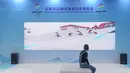 Seorang wanita menonton video promosi olahraga musim dingin di paviliun pameran outdoor di dekat China National Convention Center, lokasi penyelenggaraan Pameran CIFTIS), di Beijing Olympic Park di Beijing, China (1/9/2020).  (Xinhua/Peng Ziyang)