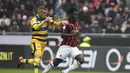 Pemain AC Milan, Frank Kessie melewati pemain Parma dalam laga lanjutan giornata ke-14 Serie A yang berlangsung di stadion San Siro, Milan, Minggu (2/12). AC Milan menang 2-1. (AFP/Miguel Medina)