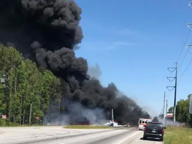 Kepulan asap hitam mengudara setelah sebuah pesawat kargo militer Amerika Serikat jatuh di jalan raya dekat bandara Savannah, Georgia, Rabu (2/5). Sembilan orang dinyatakan tewas dalam insiden jatuhnya pesawat kargo militer C-130 itu (James Lavine via AP)