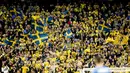 Pendukung timnas Swedia mengibarkan bendera dan meneriakan yel-yel saat menyaksikan pertandingan antara Swedia menjamu Italia dalam kualifikasi Piala Dunia 2018 di Solna, Swedia (10/11). Swedia menang 1-0 atas Italia. (AP Photo/Frank Augstein)