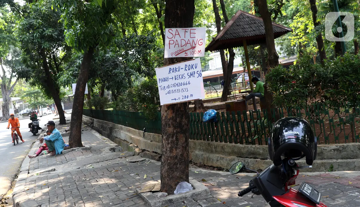 Lembaran informasi pedagang kuliner dipaku di batang pohon di Jalan Wijaya, Jakarta, Kamis (21/11/2019). Setiap 21 November diperingati sebagai Hari Pohon Sedunia, hal ini untuk mengingatkan masyarakat akan manfaat tanaman bagi kehidupan dan pelestarian lingkungan. (Liputan6.com/Helmi Fithriansyah)