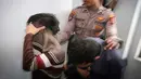 Petugas kepolisian mengawal dua orang terdakwa pasangan sejenis (gay) untuk menjalani persidangan di pengadilan syariah di Banda Aceh (17/5). Majelis hakim Mahkamah Syar'iyah Banda Aceh memvonis terdakwa dengan 85 kali cambuk. (AP Photo/Heri Juanda)
