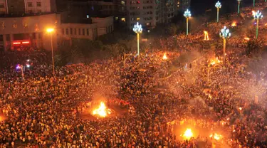 Ribuan orang merayakan Festival Obor di Xichang, Provinsi Sichuan, China, (27/7). Festival obor dirayakan oleh Etnis Yi dan kelompok lainnya dengan cara berkeliling atau pawai membawa api yang diyakini dapat mengusir hal buruk. (REUTERS / Stringer)