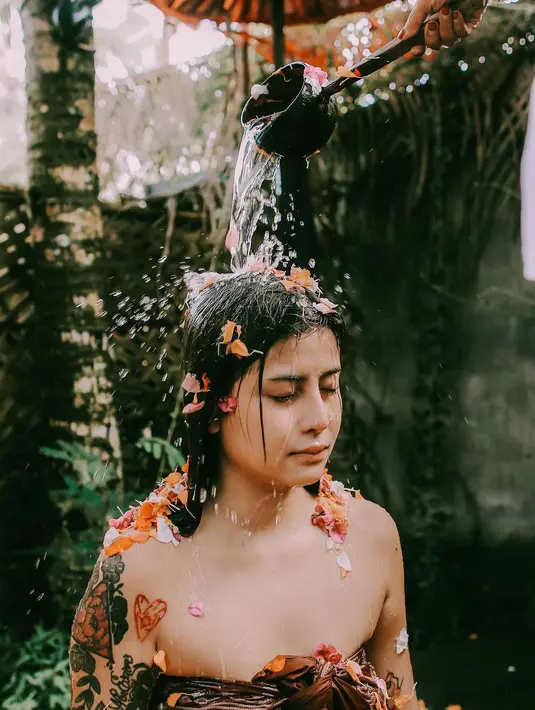 Dalam ritual ini Awkarin membalut tubuhnya dengan kain dan mandi air kembang. (Foto: Instagram/ awkarin)