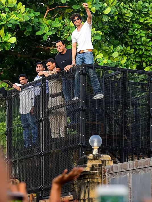 Shah Rukh Khan memberikan isyarat kepada para penggemar pada perayaan ulang tahunnya ke-54 dari balkon rumah King of Bollywood itu di Mumbai, Sabtu (2/11/2019). Seperti biasa, Shahrukh melakukan 'ritual' tahunan dengan menyapa para fans yang sudah berkumpul. (Sujit Jaiswal/AFP)
