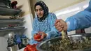 Para wanita membuat maftoul atau couscous di Khan Yunis, Jalur Gaza, Palestina, 10 Januari 2022. Maftoul disajikan bersama sup ayam yang sudah pasti menghangatkan tubuh saat musim dingin di Palestina. (SAID KHATIB/AFP)