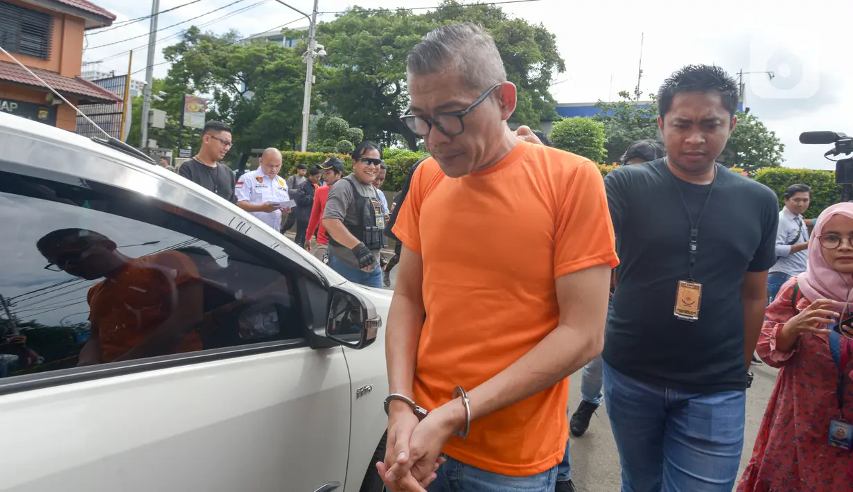 Pengemudi yang mendorong-dorong dan mencekik polisi saat hendak ditilang dekat Gerbang Tol Angke tertunduk saat diamankan Polres Jakarta Barat, Sabtu (8/2/2020). Polisi menangkap pria berinisial TS tersebut setelah videonya mengajak duel polisi sempat viral di media sosial. (merdeka.com/Imam Buhori)