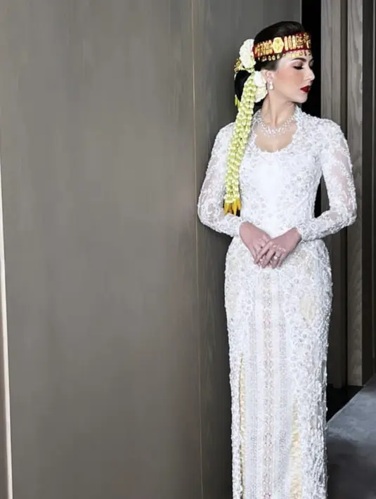Untuk resepsi kali ini, Jessica memilih mengenakan kebaya panjang berpayet putih dari Vera Anggraini. Credit: Instagram (@thebridestory)