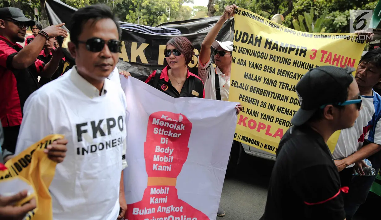Puluhan pengemudi transportasi online menggelar aksi di depan kantor Kementerian Perhubungan, Jakarta, Rabu (25/10). Dalam aksinya mereka menolak revisi PM 26P / 2017 terkait aturan taksi online. (Liputan6.com/Faizal Fanani)