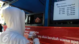 Warga menukarkan uang di mobil layanan penukaran uang receh di Monas, Jakarta, Selasa (30/6/2015). Bank Indonesia bekerjasama dengan 14 bank lainnya membuka loket penukaran uang pecahan kecil sejak 17 Juni-15 Juli 2015. (Liputan6.com/Faizal Fanani)