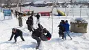 Sejumlah pria bermain di lapangan yang tertutup salju di Srinagar, kawasan Kashmir yang dikuasai India, Sabtu (5/1). Wilayah Kashmir mengalami salju selama beberapa hari yang mengakibatkan terputus jalan raya Jammu-Srinagar (AP Photo/Dar Yasin)