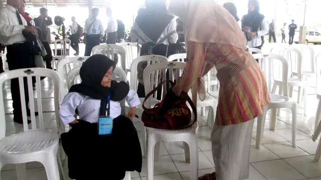 Sejak SMP hingga kuliah, Teti sabar mengantar, menggendong dan menunggui putrinya yang difabel, Anisa. (Foto: Liputan6.com/Muhamad Ridlo).