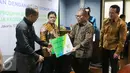 Dirut BPJS Ketenagakerjaan Agus Susanto memberikan kartu peserta usai menandatangani nota kesepahaman, Jakarta, (13/9). Kerjasama dilakukan untuk melindungi para pekerja dan pelaku usaha ekonomi kreatif yang ada di Indonesia. (Liputan6.com/Angga Yuniar)