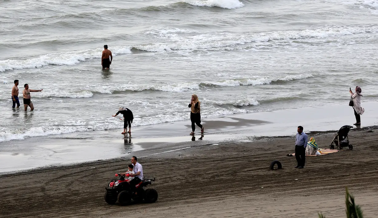 Warga Iran beraktivitas di pantai di kota Laut Kaspia, Izadshahr, di provinsi Mazandaran utara (8/7/2019). Iklim di wilayah sekeliling laut ini adalah subtropis lembap, dikarenakan karena banyaknya uap air dari danau tersebut. (AFP Photo/Atta Kenare)