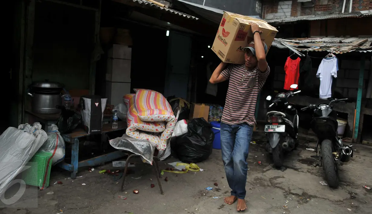 Warga memanggul kardus berisi barang miliknya dari rumah yang akan dibongkar di kawasan Kalijodo, Jakarta, Kamis (18/2). Gubernur DKI hari ini mengirim SP 1 kepada warga untuk mengosongkan dan membongkar sendiri rumah mereka. (Liputan6.com/Gempur M Surya)