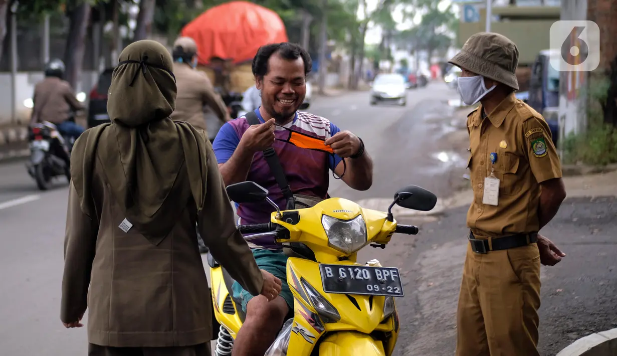 Petugas merazia warga yang tidak mengenakan masker di Kelurahan Cimone, Kota Tangerang, Banten, Rabu (15/7/2020). Guna memberi efek jera, Pemkot Tangerang memberlakukan sanksi sosial kepada pelanggar PSBB seperti menyapu dengan memakai rompi bertulis ‘Pelanggar PSBB’. (Liputan6.com/Angga Yuniar)