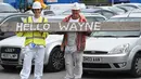 Dua pekerja menyambut pemain baru Everton, Wayne Rooney di luar Goodison Park di Liverpool (10/8). Selama 13 tahun memperkuat Manchester United akhirnya Wayne Rooney kembali klub yang membesarkan namanya Everton. (AFP Photo/Paul Ellis)