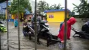 Seorang pengendara motor menggunakan jasa gerobak untuk menerobos banjir di Jalan Gunung Sahari, Jakarta Pusat, Selasa (21/2). Hujan deras yang mengguyur sejak Selasa dini hari membuat sebagian wilayah di Jakarta banjir. (Liputan6.com/Faizal Fanani)