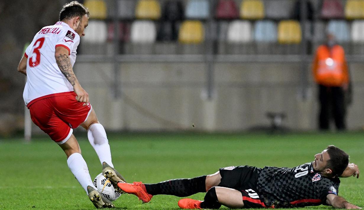 Pemain Kroasia Josip Juranovic (kiri) coba dihentikan pemain Malta Ryan Camenzuli pada pertandingan Grup H kualifikasi Piala Dunia 2022 di Stadion Rujevica, Rijeka, Kroasia, Selasa (30/3/2021). (Denis LOVROVIC/AFP)