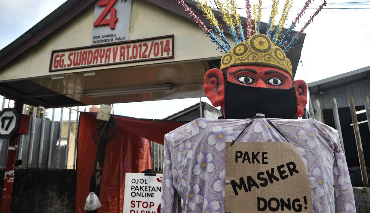 Ondel-ondel mengenakan masker terlihat di depan pintu masuk permukiman RT 12 RW 14, Cipinang Besar Utara, Jakarta, Kamis (16/4/2020). (merdeka.com/Iqbal S. Nugroho)