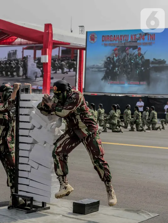 Personel TNI memecahkan batako saat menunjukan aksi bela diri usai mengikuti upacara gladi bersih HUT ke-74 TNI di Lapangan Udara (Lanud) Halim Perdanakusuma, Jakarta, Kamis (3/10/2019). (Liputan6.com/Faizal Fanani)