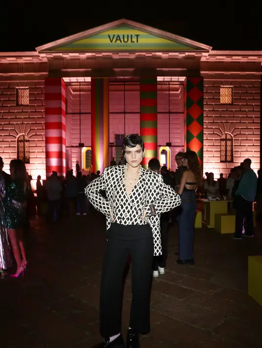 Paduan Gucci Overtue dan Black G rumble printed jacket disertai celana berbahan wool memberi kesan edgy. Sentuhan klasik hadir dalam untaian kalung mutiara bertumpuk yang dikenakannya. (Foto: Gucci).