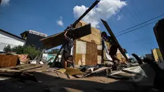 Warga mengambil sisa puing bangunan seusai penertiban bangunan liar di sepanjang bantaran tanggul barat Kali Angke, Jakarta, Senin (30/3/2015). Pembongkaran dilakukan lantaran lokasi tersebut diperuntukkan sebagai jalur hijau. (Liputan6.com/Faizal Fanani)