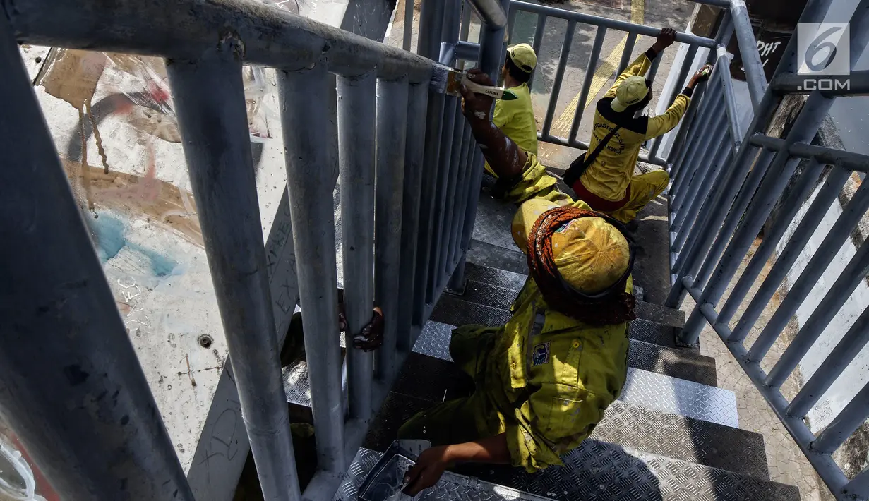 Petugas Dinas Bina Marga DKI Jakarta mengecat jembatan penyeberangan orang (JPO) di Jalan Daan Mogot, Jakarta Barat, Rabu (7/8/2019). Pengecatan ini bagian dari perawatan fasilitas umum agar masyarakat bisa menggunakan JPO dengan baik. (Liputan6.com/JohanTallo)