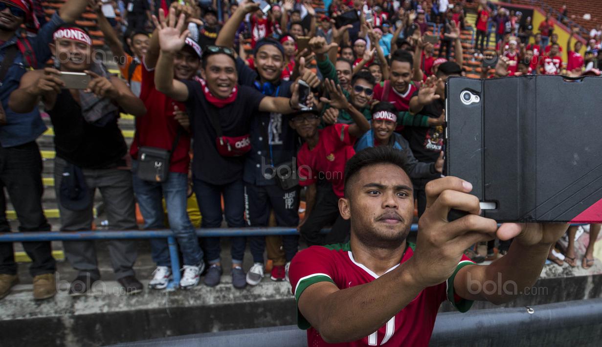 4. Gelandang Timnas Indonesia, Saddil Ramdani, melakukan swafoto dengan suporter usai laga melawan Thailand. (Bola.com/Vitalis Yogi Trisna)