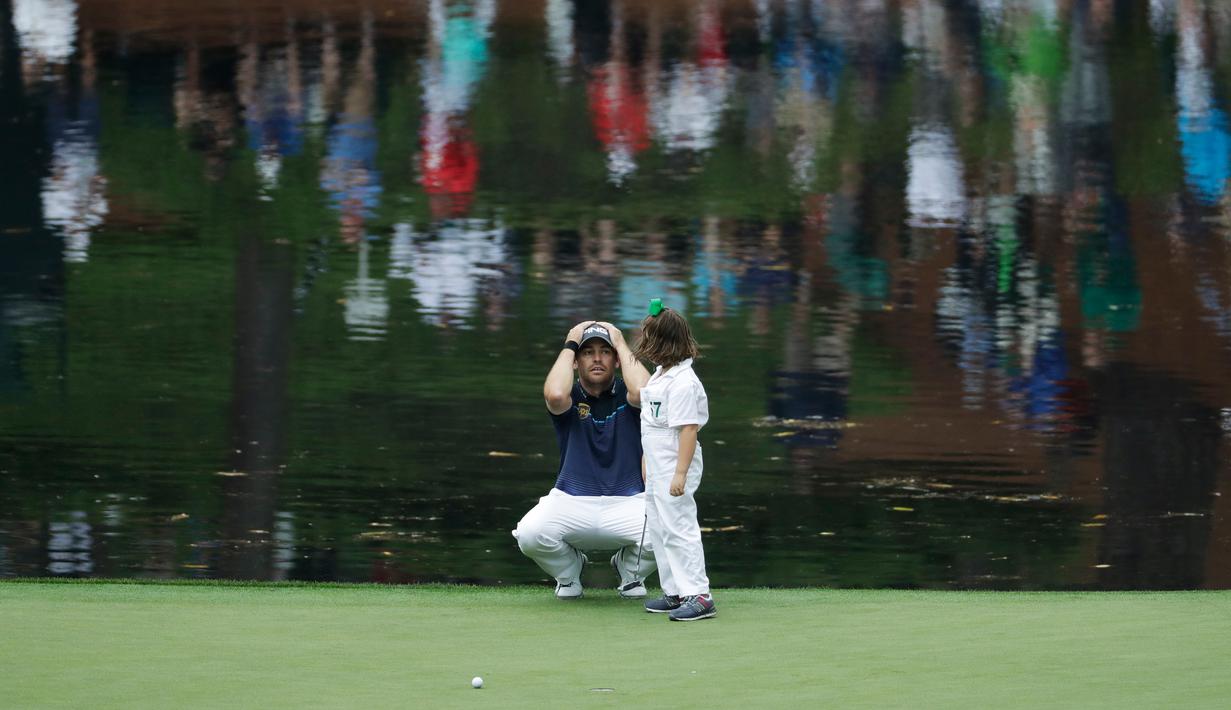 Pegolf Louis Oosthuizen dari Afrika Selatan berbincang dengan putrinya Jana putts saat mengikuti acara Masters Par 3 Tournament di Augusta National Golf Club, Georgia, (5/4). (AP Photo / Matt Slocum)