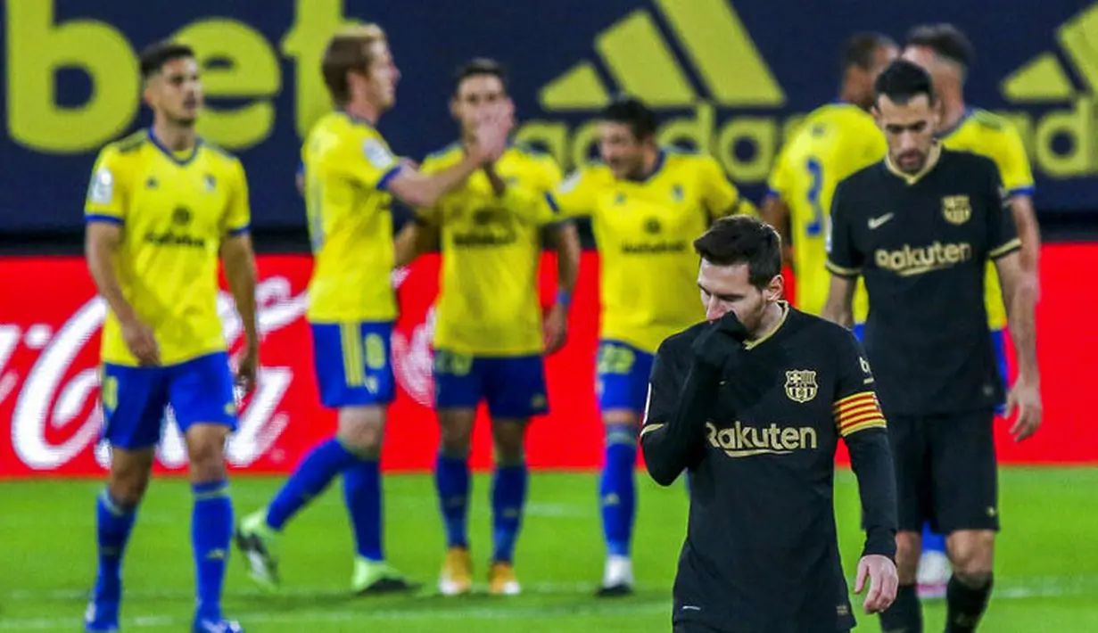Striker Barcelona, Lionel Messi, tertunduk lesu usai ditaklukkan Cadiz pada laga Liga Spanyol di Stadion Ramon Carranza, Minggu (6/12/2020). Barcelona takluk dengan skor 1-2. (AP/Alvaro Rivero)